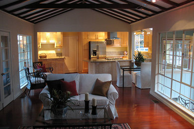 Modelo de sala de estar abierta de estilo americano de tamaño medio con paredes beige, suelo de madera en tonos medios y suelo marrón