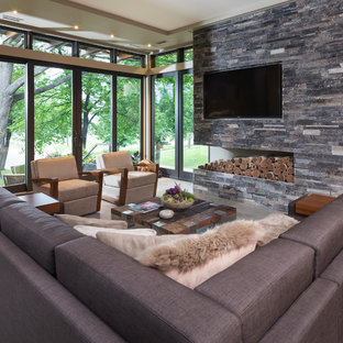 Family room - small modern open concept concrete floor family room idea in Minneapolis with beige walls, no fireplace, a stone fireplace and a wall-mounted tv