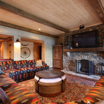 Family room - large rustic open concept medium tone wood floor and brown floor family room idea in Atlanta with a standard fireplace, a stone fireplace, a wall-mounted tv and beige walls