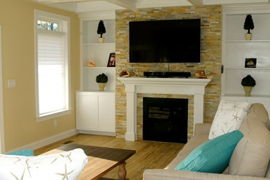 Modelo de sala de estar abierta costera pequeña con suelo de baldosas de porcelana, todas las chimeneas, marco de chimenea de piedra y pared multimedia