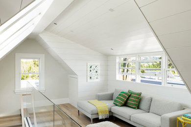 Diseño de sala de estar tipo loft y abovedada costera de tamaño medio con suelo de madera clara y machihembrado