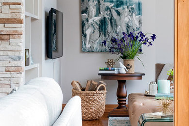 Offenes Uriges Wohnzimmer mit grauer Wandfarbe, braunem Holzboden, Kamin, Kaminumrandung aus Backstein und TV-Wand in Montreal
