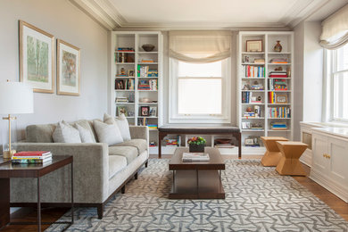 Diseño de sala de estar con biblioteca cerrada bohemia de tamaño medio sin chimenea y televisor con paredes grises, suelo de madera clara y suelo beige