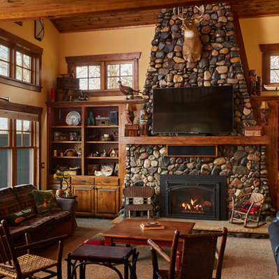 Example of a mid-sized mountain style open concept carpeted and beige floor family room design in Minneapolis with beige walls, a standard fireplace, a stone fireplace and a wall-mounted tv