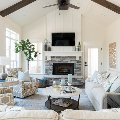 Mid-sized beach style dark wood floor family room photo with white walls, a standard fireplace, a stone fireplace and a wall-mounted tv