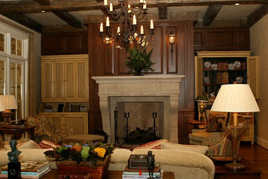 Foto de sala de estar cerrada rural de tamaño medio con paredes beige, suelo de madera oscura, todas las chimeneas y marco de chimenea de piedra