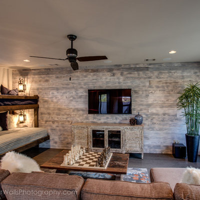 Inspiration for a mid-sized rustic enclosed medium tone wood floor family room remodel in Austin with a bar, beige walls, no fireplace and a wall-mounted tv