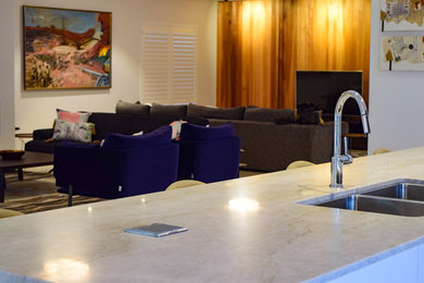 Imagen de sala de estar abierta moderna de tamaño medio con paredes beige y televisor independiente