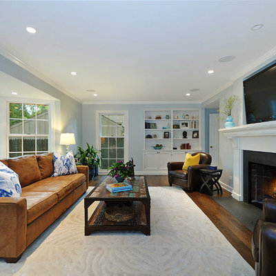 Family room - traditional medium tone wood floor family room idea in Chicago with blue walls, a standard fireplace and a wall-mounted tv