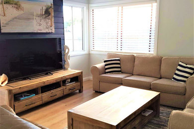 Modelo de sala de estar actual con suelo laminado y televisor independiente