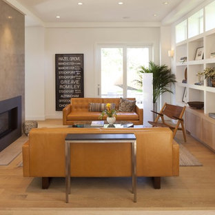 Example of a minimalist medium tone wood floor family room design in Minneapolis with white walls, a standard fireplace and no tv
