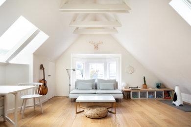Modelo de sala de estar abierta escandinava pequeña con paredes blancas, suelo de madera clara y suelo beige