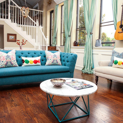 Example of a mid-sized eclectic medium tone wood floor family room design in Houston with beige walls
