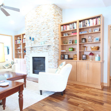 Living Room with Vaulted Ceiling, Stacked stone fireplace, and Cherry Book Shelv