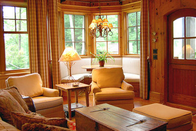 Example of a mid-sized mountain style enclosed medium tone wood floor family room library design in Other with brown walls, no fireplace, a wood fireplace surround and a wall-mounted tv