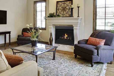 Example of a mid-sized trendy open concept light wood floor and beige floor family room design in Seattle with a standard fireplace, a plaster fireplace, white walls and a wall-mounted tv