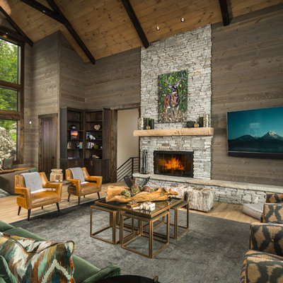 Example of a mountain style light wood floor family room design in Charlotte with brown walls, a ribbon fireplace, a stone fireplace and a wall-mounted tv