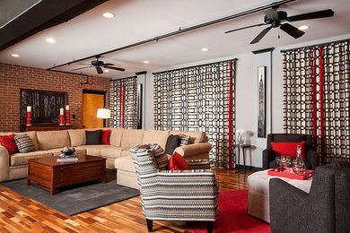 Example of a large transitional loft-style medium tone wood floor family room design in Other with white walls, a corner fireplace and a brick fireplace