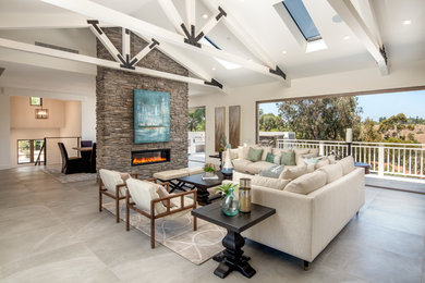 Example of a transitional open concept gray floor family room design in San Diego with white walls, a ribbon fireplace and a stone fireplace