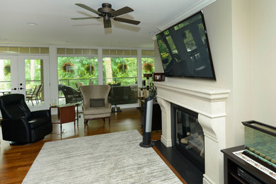Example of a mid-sized classic family room design in Toronto with beige walls, a standard fireplace, a concrete fireplace and a wall-mounted tv