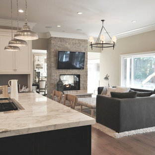 Inspiration for a mid-sized transitional open concept family room in San Francisco with beige walls, medium hardwood floors, a two-sided fireplace, a stone fireplace surround, a wall-mounted tv and brown floor.