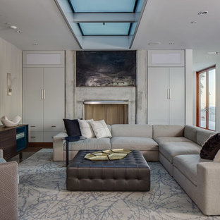 Large minimalist open concept brown floor family room photo in San Francisco with a standard fireplace, a concrete fireplace, a wall-mounted tv and white walls