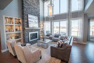 Transitional medium tone wood floor family room photo in Calgary with a two-sided fireplace and a stone fireplace
