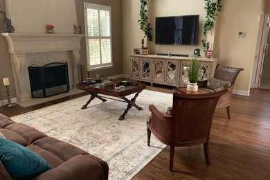 Mid-sized elegant open concept dark wood floor and brown floor family room photo in Atlanta with brown walls, a standard fireplace, a stone fireplace and a wall-mounted tv