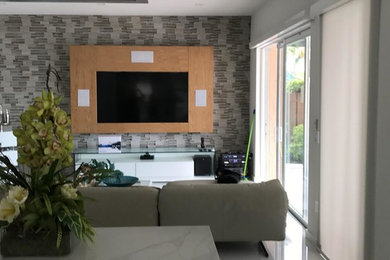 Foto de sala de estar abierta tradicional renovada de tamaño medio con paredes multicolor y televisor colgado en la pared
