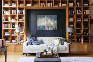 Diseño de sala de estar con biblioteca tradicional renovada con paredes azules, suelo de madera en tonos medios y suelo marrón