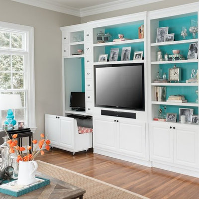 Example of a trendy medium tone wood floor family room design in New York with beige walls and a media wall