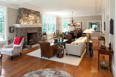 Inspiration for a large transitional open concept light wood floor family room library remodel in Portland Maine with beige walls, a standard fireplace and a stone fireplace