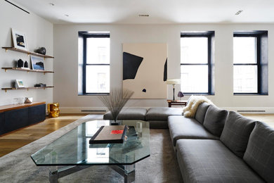 Ejemplo de sala de estar tipo loft actual con paredes blancas, suelo de madera en tonos medios, televisor independiente y suelo marrón