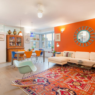 Offenes Modernes Wohnzimmer mit oranger Wandfarbe und hellem Holzboden in New York