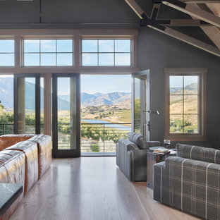 Immagine di un grande soggiorno country aperto con pareti beige, parquet chiaro, stufa a legna, cornice del camino in mattoni, porta TV ad angolo e pavimento beige