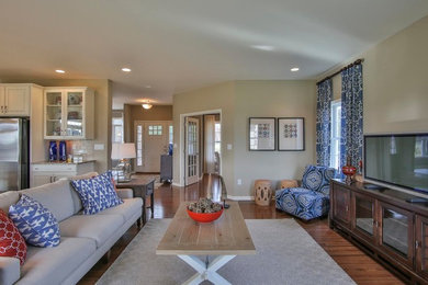 Imagen de sala de estar abierta bohemia de tamaño medio sin chimenea con paredes beige, suelo de madera en tonos medios y televisor independiente