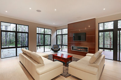 Foto de sala de estar abierta contemporánea con paredes beige, suelo de madera clara, chimenea lineal, marco de chimenea de madera, televisor colgado en la pared y alfombra