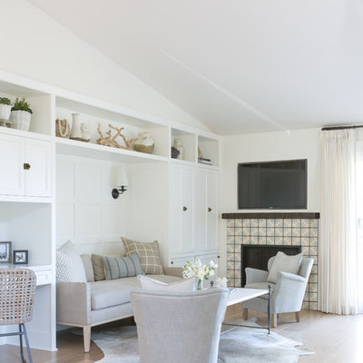 Inspiration for a coastal light wood floor and beige floor family room remodel in San Francisco with white walls, a standard fireplace, a tile fireplace and a wall-mounted tv