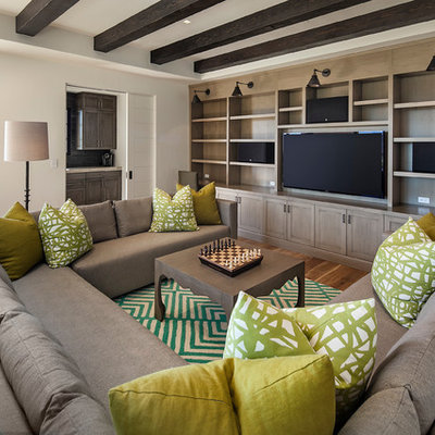 Example of a large trendy enclosed medium tone wood floor family room library design in Santa Barbara with white walls and a media wall
