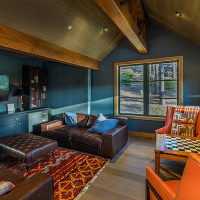 Mountain style enclosed dark wood floor and brown floor game room photo in Sacramento with black walls and a wall-mounted tv