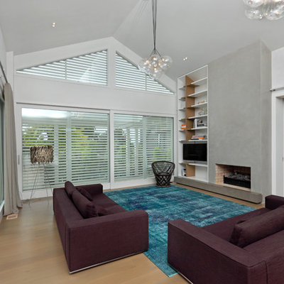 Example of a trendy open concept light wood floor family room design in Auckland with white walls, a standard fireplace and a tv stand