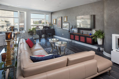 Ejemplo de sala de estar abierta contemporánea de tamaño medio sin chimenea con paredes grises, suelo de baldosas de porcelana, televisor colgado en la pared y suelo marrón
