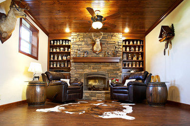 Mid-sized mountain style medium tone wood floor family room photo in St Louis with beige walls, a standard fireplace and a stone fireplace