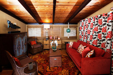 Diseño de sala de estar abierta exótica de tamaño medio sin chimenea con paredes beige, suelo de madera en tonos medios, televisor retractable y suelo marrón