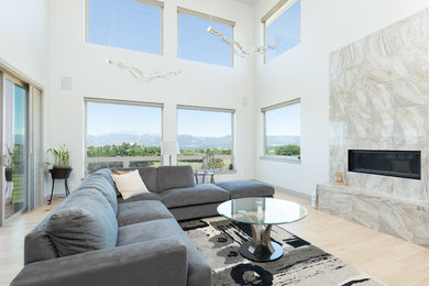 Imagen de sala de estar abierta moderna con paredes blancas, suelo de madera clara, chimenea lineal y marco de chimenea de baldosas y/o azulejos