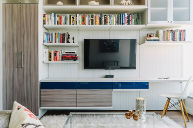 Imagen de sala de estar contemporánea de tamaño medio sin chimenea con paredes blancas, suelo de madera en tonos medios y televisor colgado en la pared