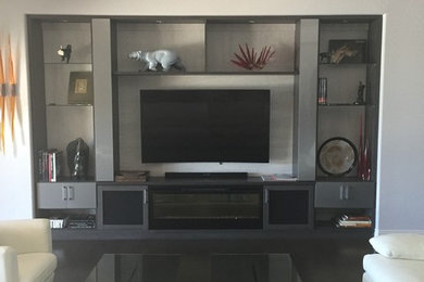 Large trendy open concept ceramic tile family room photo in Las Vegas with gray walls, a standard fireplace and a media wall