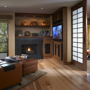 Family room - contemporary enclosed family room idea in San Francisco with beige walls, a standard fireplace and a wall-mounted tv