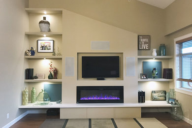 Example of a small transitional open concept laminate floor family room design in Vancouver with beige walls, a hanging fireplace and a media wall
