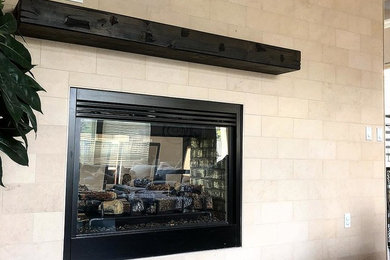 サクラメントにあるお手頃価格の広い地中海スタイルのおしゃれなオープンリビング (ベージュの壁、磁器タイルの床、両方向型暖炉、タイルの暖炉まわり) の写真